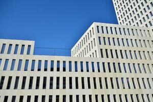 Modern office building detail. Perspective view of geometric angular concrete windows on the facade of a modernist brutalist style building. photo