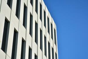 Modern office building detail. Perspective view of geometric angular concrete windows on the facade of a modernist brutalist style building. photo