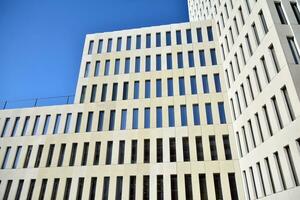 Modern office building detail. Perspective view of geometric angular concrete windows on the facade of a modernist brutalist style building. photo