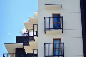 Fragment of modern luxury residential apartment,  home house building concept. Modern apartment building on a sunny day with a blue sky. photo