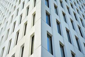 Modern office building detail. Perspective view of geometric angular concrete windows on the facade of a modernist brutalist style building. photo