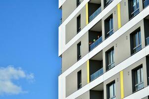 fragmento de moderno lujo residencial departamento, hogar casa edificio concepto. moderno Departamento edificio en un soleado día con un azul cielo. foto