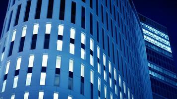 Pattern of office buildings windows illuminated at night. Glass architecture ,corporate building at night - business concept. Blue graphic filter. photo