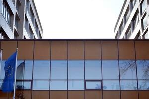 Modern office building with glass facade on a clear sky background. Transparent glass wall of office building. photo