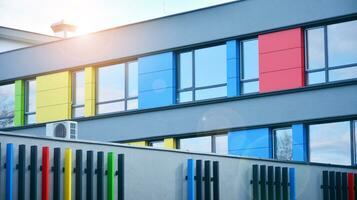 A view at a straight facade of a modern building with a dark grey facade. Dark grey metallic panel facad. Modern architectural details. photo