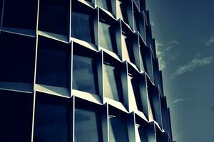 moderno oficina edificio con vaso fachada en un claro cielo antecedentes. transparente vaso pared de oficina edificio. foto