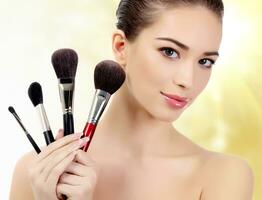 Pretty woman with cosmetic brushes photo
