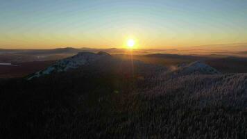 dvuglavaya kulle och barr- skog täckt med snö på solnedgång. antenn se. taganay nationell parkera, sydlig uraler, Ryssland. Drönare flugor sidled video