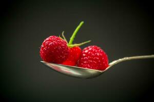 Sweet raspberry fruit isolated on black background photo