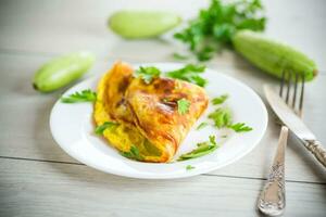 frito tortilla con calabacín, en un de madera mesa. foto