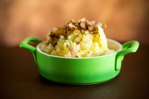 Cooked mashed potatoes with fried chopped bacon and onions. photo