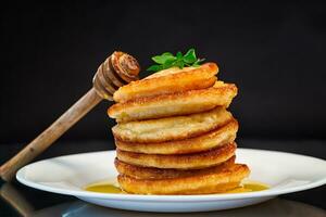 cooked sweet pancakes with honey in a plate photo