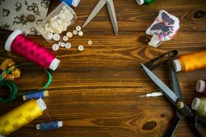 Sewing accessories and fabric on a wooden background. photo