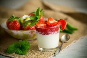 sweet homemade yogurt with strawberry jam and fresh strawberries in a glass cup photo