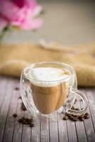 A cup of hot coffee with milk with coffee beans photo