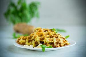 fried potato waffles with cheese in a plate on wooden table. photo