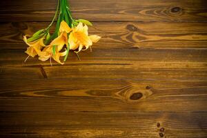 ramo de flores de hermosa amarillo lirios en de madera mesa foto