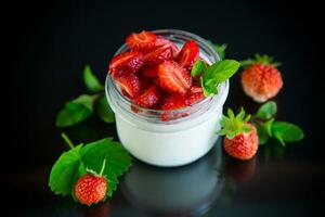 Sweet homemade yogurt with fresh ripe strawberries in a glass jar photo