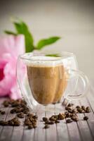 A cup of hot coffee with milk with coffee beans photo