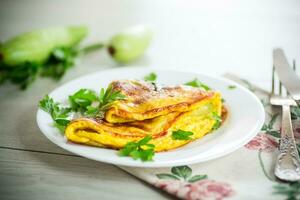 frito tortilla con calabacín, en un de madera mesa. foto