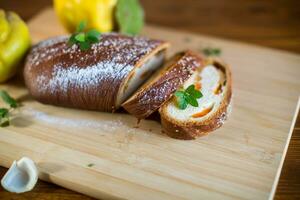 Cooked sweet pie with quince and pumpkin inside, yeast dough roll. photo