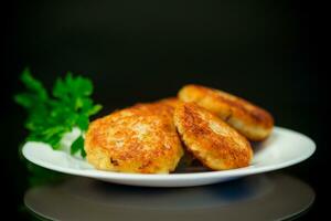 Cooked fried fish cutlets in a plate with herbs. photo