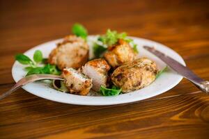 Fried pieces of chicken fillet breaded with spices and herbs in a plate . photo