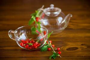 Branch with ripe red goji berry on wooden table photo