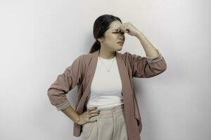 A sad Asian woman employee wears cardigan, looks stressed and depressed, isolated white background. photo