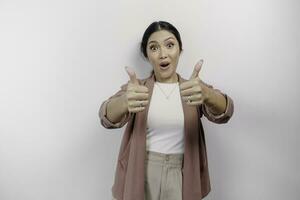Excited young Asian woman employee is gesturing thumbs up for approval, isolated by white background photo