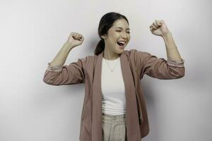 A young Asian woman employee with a happy successful expression wearing cardigan isolated by white background photo