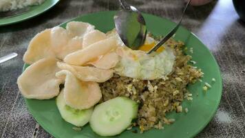 allí es un plato frito arroz de alimento, pepinos, y un cuchara video