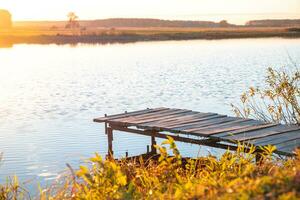 Wooden pier on the river. Autumn, sunset photo