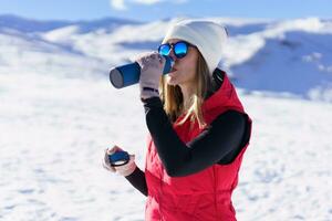 Young woman drinking water from bottle in highlands photo