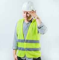 Worried young engineer holding forehead isolated. Frustrated young engineer holding forehead and looking down. Worried male engineer man holding forehead photo