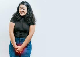 Young woman with urinary problems isolated. Girl with hands on crotch with urinary problems. People with urinary incontinence on white background photo