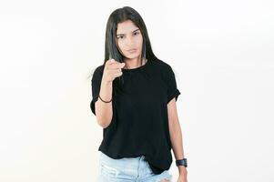 Young girl pointing at you frowning isolated. Serious girl pointing at the camera, isolated photo