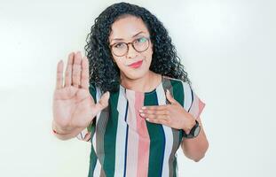 Afro girl gesturing stop isolated. Latin girl gesturing stop with palm hand isolated. Young afro woman rejecting with the palm hand isolated photo