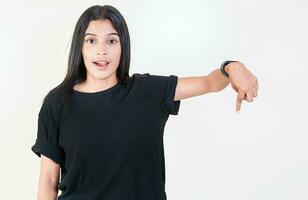 Amazed latin girl pointing down an advertisement. Cheerful girl pointing advertising down. Latin people pointing down at a banner photo