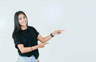 Cheerful teen girl pointing an offer isolated. Beautiful young girl pointing to a banner to the side. Happy latin woman pointing a promo isolated photo