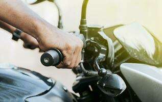 Hands of a person on the handlebar of a motorcycle, Close up of the hands of a motorcycle driver, Close up of hands on the handlebar of a motorcycle photo