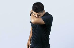 People sneezing with his elbow, A guy sneezing with his elbow on isolated background, concept of man having a cold sneezing with his elbow photo