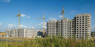 tower cranes on construction site, providing housing for low-income citizens of third world countries photo