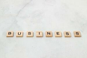 Top view of Business word on wooden cube letter block on white background. Business concept photo