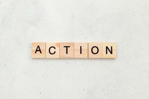Top view of Action word on wooden cube letter block on white background. Business concept photo
