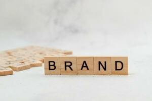 Top view of Brand word on wooden cube letter block on white background. Business concept photo