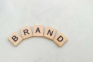 Top view of Brand word on wooden cube letter block on white background. Business concept photo