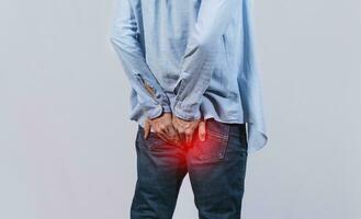 Man with digestive problem touching his buttock, man with hemorrhoid problem on isolated background, Man with diarrhea problem photo