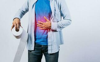 Man with stomach problems holding toilet paper, Person with toilet paper with stomach problems on isolated background, Concept of a person with digestive problems photo