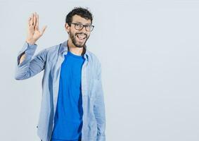 Man raising arm and waving friendly, isolated handsome man saying hi, friendly face man saying goodbye, concept of man saying hi on isolated background photo